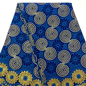 May include: Blue and gold fabric with a repeating pattern of stylized flowers and swirls. The fabric has a textured surface.