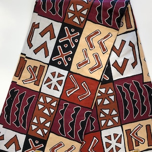 May include: A fabric with a geometric pattern in shades of brown, white, and black. The pattern features zigzags, waves, and stars.