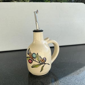 May include: A white ceramic mug with a black handle and the text "But First, Coffee" in a black, bold font. The mug is on a white surface.