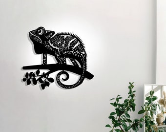 Könnte beinhalten: Schwarze Wandkunst aus Metall mit einem Chamäleon, das auf einem Ast sitzt. Das Chamäleon ist in einem stilisierten, detaillierten Design mit einer strukturierten Oberfläche dargestellt.