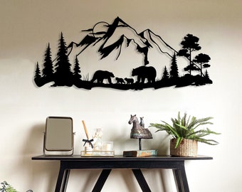 Puede incluir: Arte de pared de metal negro que representa una cordillera con una luna y una familia de osos caminando por un bosque. El arte se exhibe en una pared blanca sobre una mesa consola negra con un espejo, artículos decorativos y una planta en maceta.