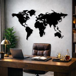 May include: A black world map is mounted on a grey wall above a wooden desk. The desk has a laptop, a leather chair, and a lamp. A tray with glasses and a bottle sits on the desk.