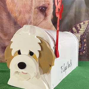 May include: A white mailbox with a dog-shaped front, featuring a red paw-shaped flag. The dog's face is white, brown, and black. The text "75 Eagle View Rd" is printed on the side. The background includes a dog portrait and a butterfly.