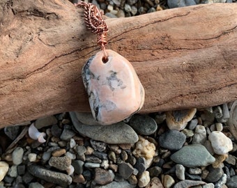 A unique polished charcoal gray and pink Maine Beach Stone Jewelry pendant necklace.