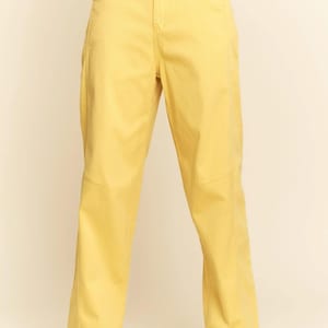 Op de afbeelding: Felgeel broek met hoge taille en een recht model. De broek heeft een klassieke vijf-zakken stijl en een knoop- en ritssluiting. Het model draagt bruine laarzen. Een stijlvolle en comfortabele toevoeging aan elke garderobe.