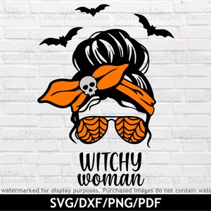 May include: A black and orange Halloween-themed design featuring a woman with a messy bun, wearing a headband with a skull and crossbones, and spiderweb-patterned sunglasses. The text "Witchy Woman" is below the image.