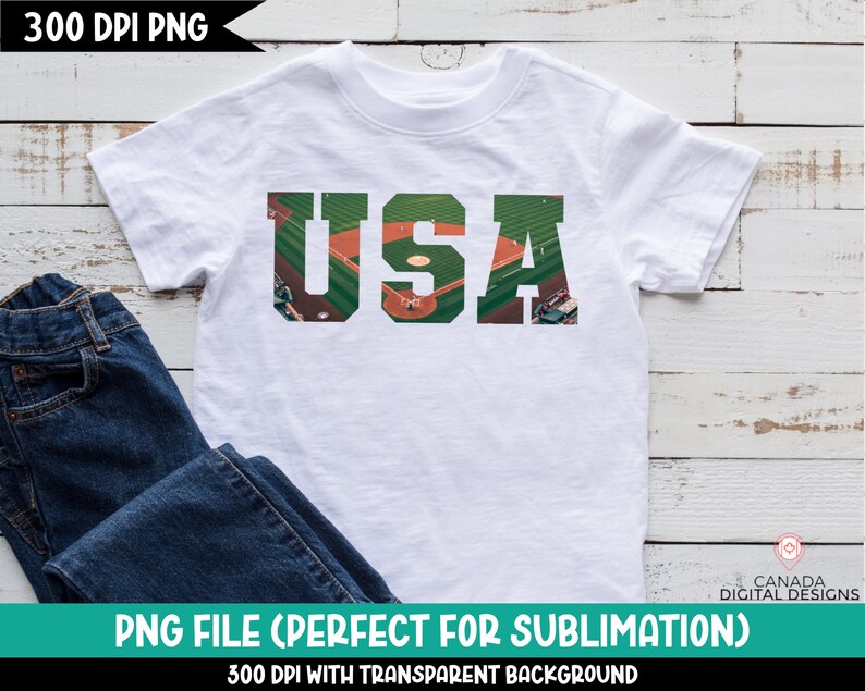 May include: White t-shirt with a graphic of the letters "USA" made up of a baseball field with players and a green outfield.