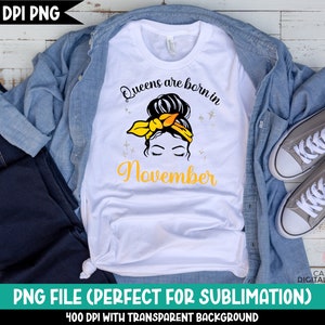 May include: White t-shirt with a graphic design of a woman with a yellow headband and the text "Queens are born in November".