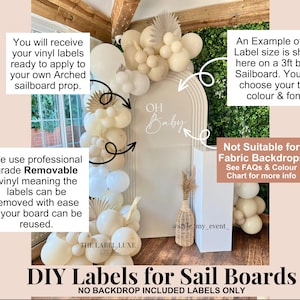 May include: Customisable white vinyl lettering reading OH Baby applied to a beige arched sailboard. The display features a balloon garland in shades of cream and white, with dried palm leaves. Text includes DIY Labels for Sail Boards.