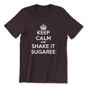 May include: A dark brown t-shirt with a white graphic that says "Keep Calm and Shake It Sugaree".