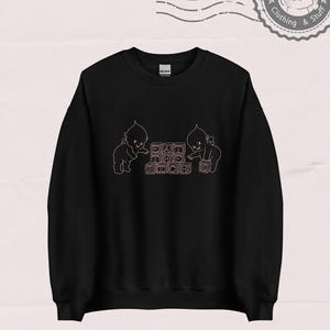 May include: Black sweatshirt with a pink graphic of two cherubs playing with blocks that spell out "DAIT THE RICH".