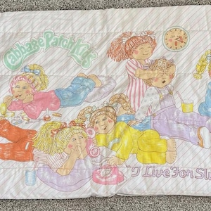May include: White Cabbage Patch Kids slumber party bed sheet with illustrations of girls in pajamas. The sheet features the text "Cabbage Patch Kids" and "I Live for Slumber Parties!"