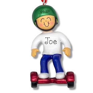 May include: A hanging ornament featuring a figure wearing a green helmet with the word year written on it, a white long-sleeved shirt with the name Joe printed on the front, blue pants, and white shoes, while standing on a red self-balancing scooter.