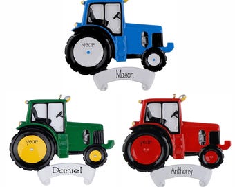 May include: Three tractor ornaments in blue, green, and red. Each tractor features a white banner at the base with the names Mason, Daniel, and Anthony printed in black. The large rear wheels have the word year printed in black on the centre hub.
