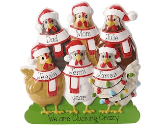 May include: A decorative resin ornament featuring six chickens wearing Santa hats and red-and-white scarves. Each chicken has a name tag: Dad, Mom, Julie, Jessie, Jenni, and James. The base is green with the text "We are Clucking Crazy" printed on it.