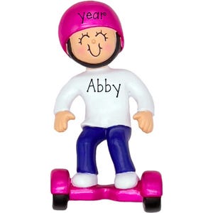 May include: A figurine of a character wearing a bright pink helmet with the word year printed on it, a white long-sleeved shirt with the name Abby printed on the front, and blue pants, while standing on a pink and black self-balancing scooter.