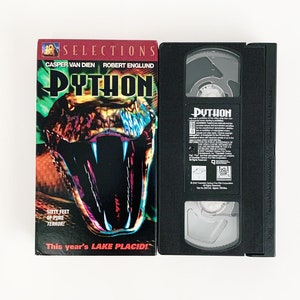 May include: A VHS tape of the movie "Python" featuring a close-up of a snake's head with the text "Sixty feet of pure terror! This year's Lake Placid!" on the cover.