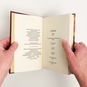 May include: A book with a maroon cover and white pages. The title page shows the book's contents, including "Preface", "The Transformation of Don Juan", "The Little Stones", "La Gorda", "The Geniuses", "The Art of Dreaming", and "The Second Attention".