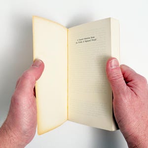 May include: A white ceramic mug with a black handle and the text "But First, Coffee" in a black, handwritten-style font. The mug is on a white surface.