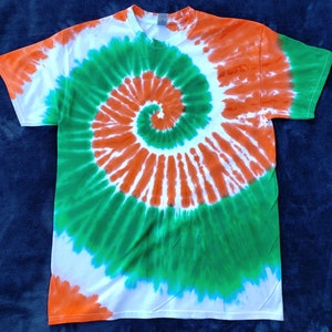 May include: A white t-shirt with a spiral tie-dye pattern in shades of orange and green.