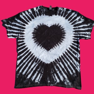 Puede incluir: Camiseta tie-dye en blanco y negro con un gran diseño de corazón en el centro.