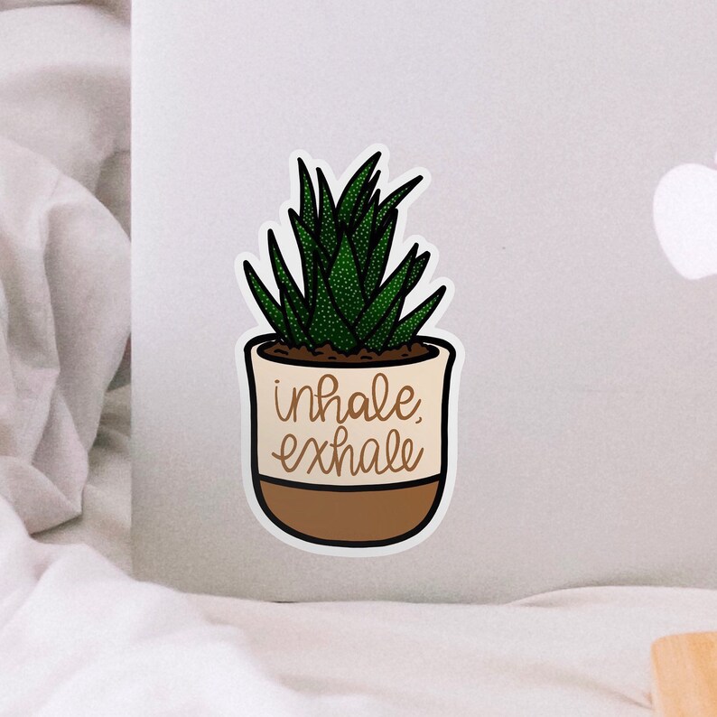 Puede incluir: Una pegatina con una planta suculenta en maceta con el texto "inhale exhale" en letras marrones.