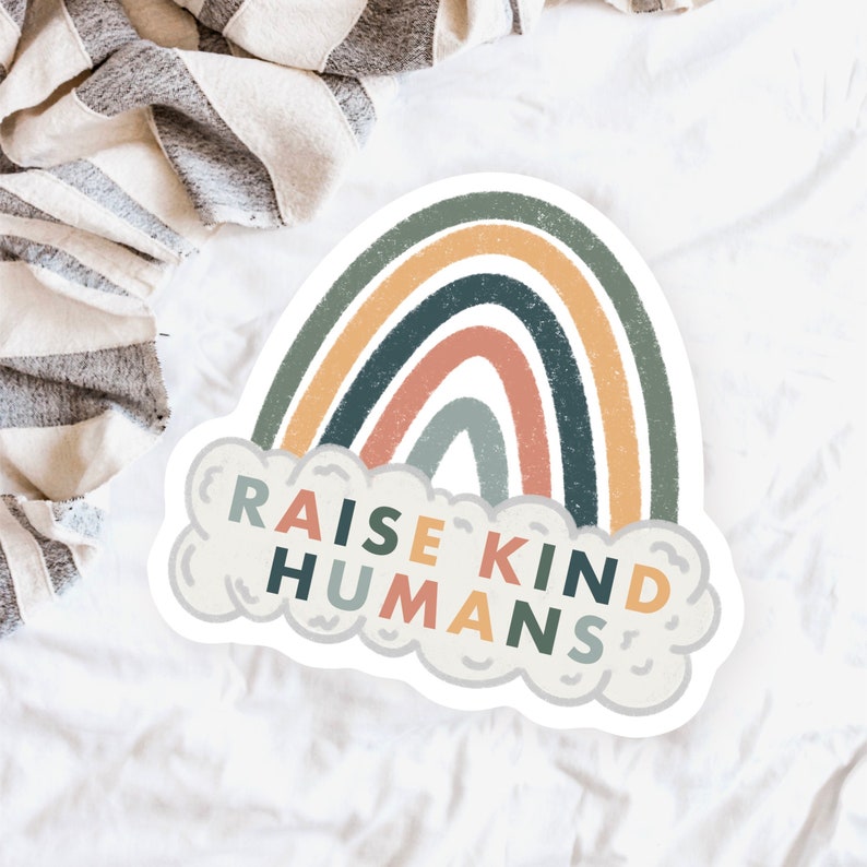 May include: A sticker featuring a rainbow design and the text "Raise Kind Humans" within a cloud shape.