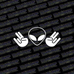 May include: White alien head with two white hands making the 'peace' sign on either side of the head. The background is black with a repeating pattern of the words 'The Slap Shop' in white.