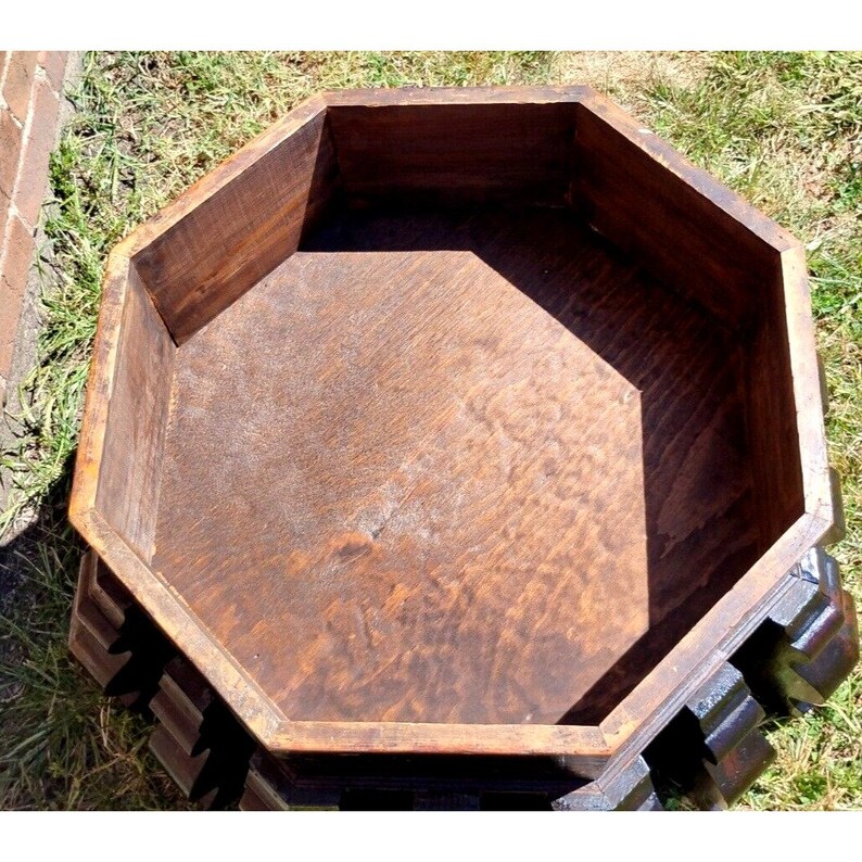 Puede incluir: Caja de madera octogonal con un acabado marr&oacute;n oscuro. La caja tiene un dise&ntilde;o tallado alrededor del borde superior y un interior liso.