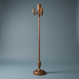 May include: A tall, slender floor lamp with a metallic bronze finish. The lamp features a central pole rising from a circular, tiered base. At the top, a multi-socket fixture includes three small, curved arms extending outward from a central column.