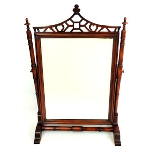 May include: A mahogany wood framed standing mirror with a decorative top and a bamboo style base.