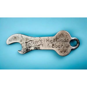 May include: A silver bottle opener with the words "Hecker's High Grade Beer" etched on the handle.