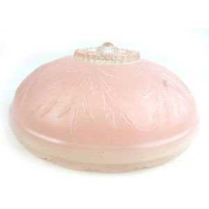 May include: A pink glass ceiling light fixture with a frosted glass shade and a clear glass top. The shade has a floral design.