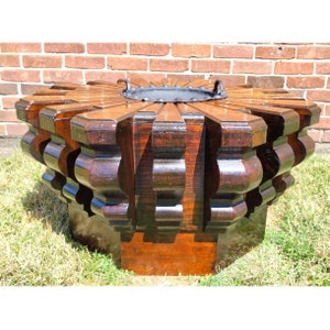 Puede incluir: Una mesa octogonal grande de madera oscura con un dise&ntilde;o de estrella y una inserci&oacute;n de metal negro en el centro. La mesa est&aacute; hecha de madera oscura y tiene un acabado rico y pulido.