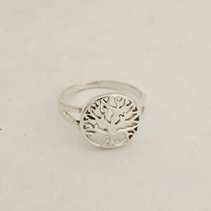 Pu&ograve; includere: Un anello d'argento con un design a forma di albero della vita. L'anello &egrave; in metallo e ha una forma circolare.