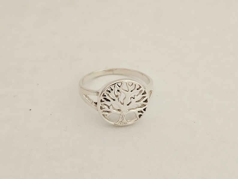 Pu&ograve; includere: Un anello d'argento con un design a forma di albero della vita. L'anello &egrave; in metallo e ha una forma circolare.