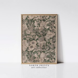 May include: A framed print of a vintage botanical illustration featuring a detailed floral pattern in shades of beige and green. The print is set against a white background and framed in a gold frame. The text "NORTH PRINTS art collective" is printed below the frame.