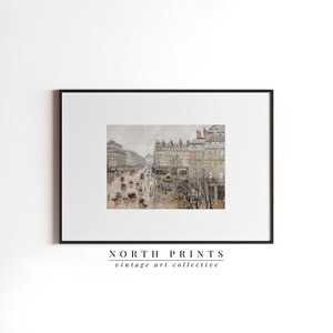 May include: A framed print showcasing a vintage street scene in muted tones. The artwork depicts a busy city street with horse-drawn carriages, buildings, and people. The print is framed in a black border and features the text "NORTH PRINTS vintage art collective".