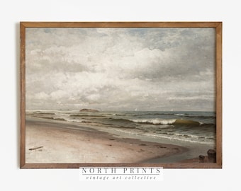 Puede incluir: Una pintura vintage de paisaje marítimo que representa una playa de arena con olas espumosas rompiendo en la orilla. El cielo está nublado y gris, con una pequeña isla en la distancia. La pintura está enmarcada en un marco de madera marrón.