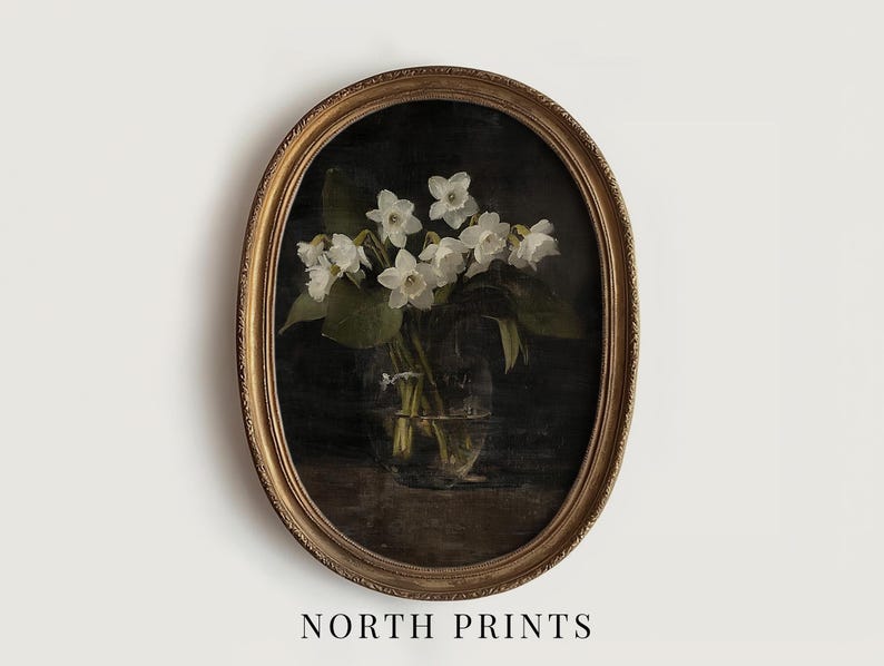 May include: A vintage oval-shaped gold frame with a dark background featuring a bouquet of white flowers in a clear glass vase.