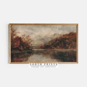 May include: A vintage landscape painting depicting a lake surrounded by trees and mountains. The painting is framed in a wooden frame and has a muted colour palette of browns, greens, and blues.