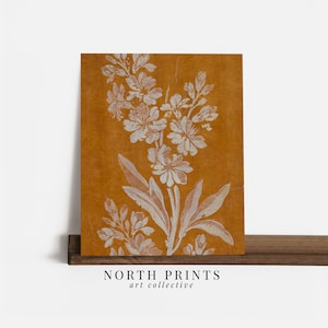 May include: A mustard yellow background with a white floral design. The design features a large flower with smaller flowers and leaves. The image is a digital print.