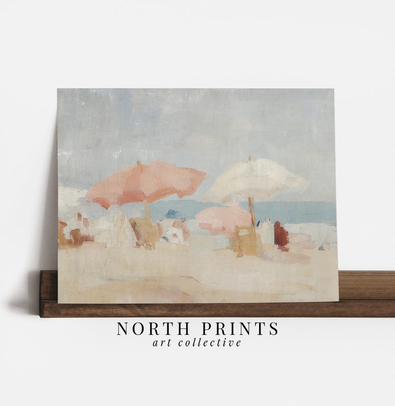 Puede incluir: Una pintura de escena de playa con cielo y oc&eacute;ano azul claro. Dos sombrillas rosas y una blanca dan sombra a la orilla arenosa. La obra de arte incluye el texto "NORTH PRINTS art collective".