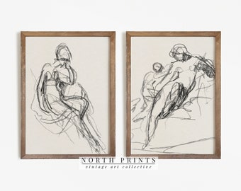 Può includere: Un set di due disegni a linea in bianco e nero incorniciati di figure. I disegni sono in stile minimalista e presentano linee e forme semplici. Le cornici sono in legno marrone chiaro.