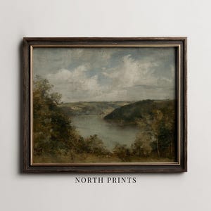 May include: Framed landscape painting featuring a serene river scene with lush green trees and a cloudy sky. The artwork is in a dark wooden frame. The text "NORTH PRINTS" is at the bottom of the frame.