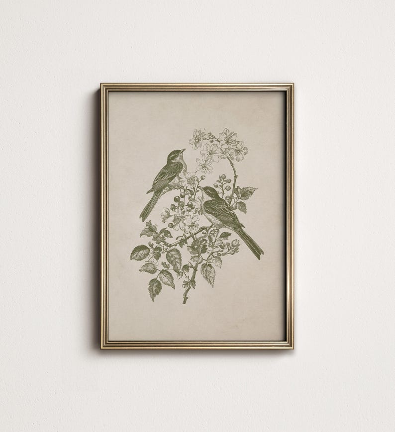 May include: A framed print featuring two birds perched on a flowering branch. The artwork is rendered in shades of green on a beige background, with a gold-colored frame. The birds and floral elements are detailed, creating a vintage aesthetic.