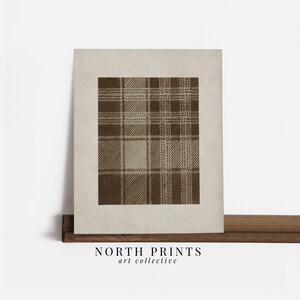 May include: A framed print featuring a brown plaid pattern on a beige background. The artwork has a vintage aesthetic, with the text "NORTH PRINTS art collective" printed at the bottom.