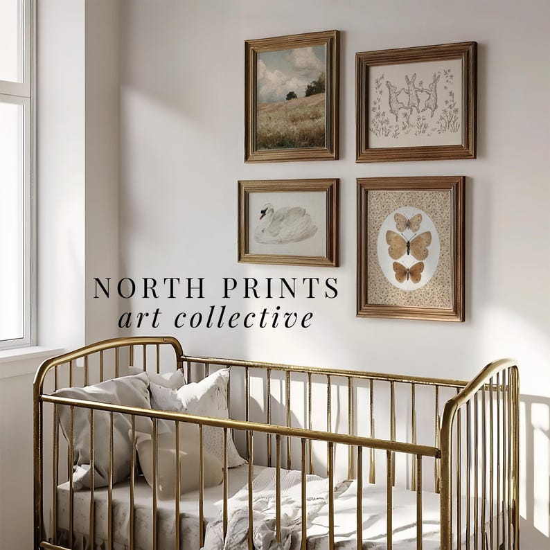 May include: A gold crib with white bedding and four framed prints on the wall behind it. The prints feature a landscape, a swan, butterflies, and rabbits. The text "NORTH PRINTS art collective" is below the prints.