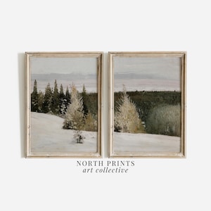 May include: Two framed landscape paintings depicting a snowy forest scene with a light blue sky. The paintings are in a light wood frame with a white mount.