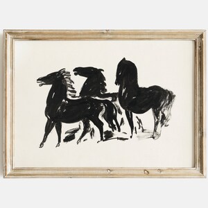 May include: Black and white ink drawing of three horses in a minimalist style. The horses are depicted in a simple, abstract manner, with their bodies and heads outlined in black ink. The drawing is framed in a light wood frame.